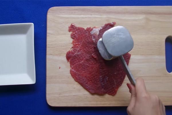 Dùng cán dao để đập nhẹ miếng thịt bò bít tết